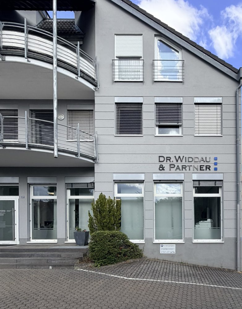 Außenansicht des Standorts von Dr. Widdau & Partner in Wittlich mit dem Firmenlogo an der Fassade.
